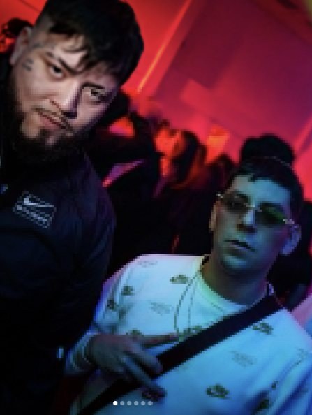 Dos personas posando en una fiesta con luz roja